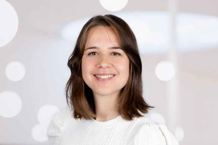 Portret van docent met wit shirt en een lichte achtergrond